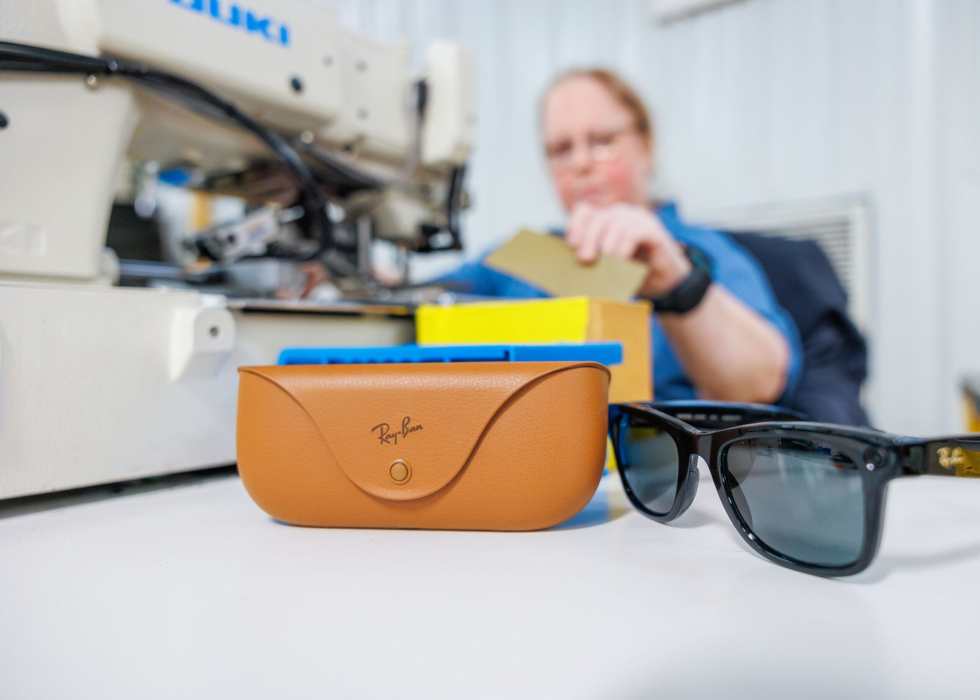 Ray-Ban smart glasses next to a Lions Services sewing operator — ROAR Fund in action